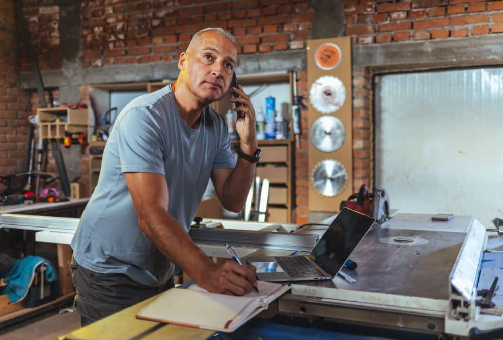 Business owner with laptop considering How Does Safe Harbour Protect Me From Insolvent Trading Claims